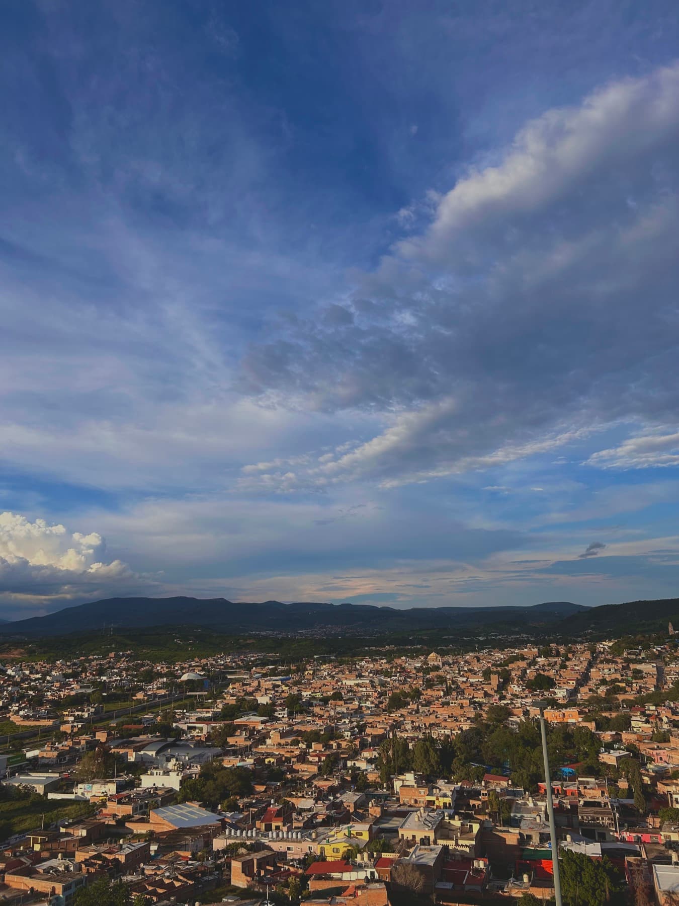 Aerial view of a town at dusk beneath a wide sky